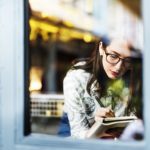 girl sitting near the window writing